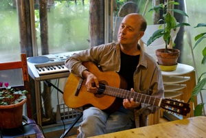 Keith playing guitar with plant at Damanhur